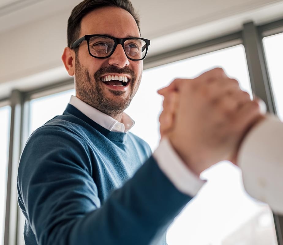 two men shaking smiling and shaking hands